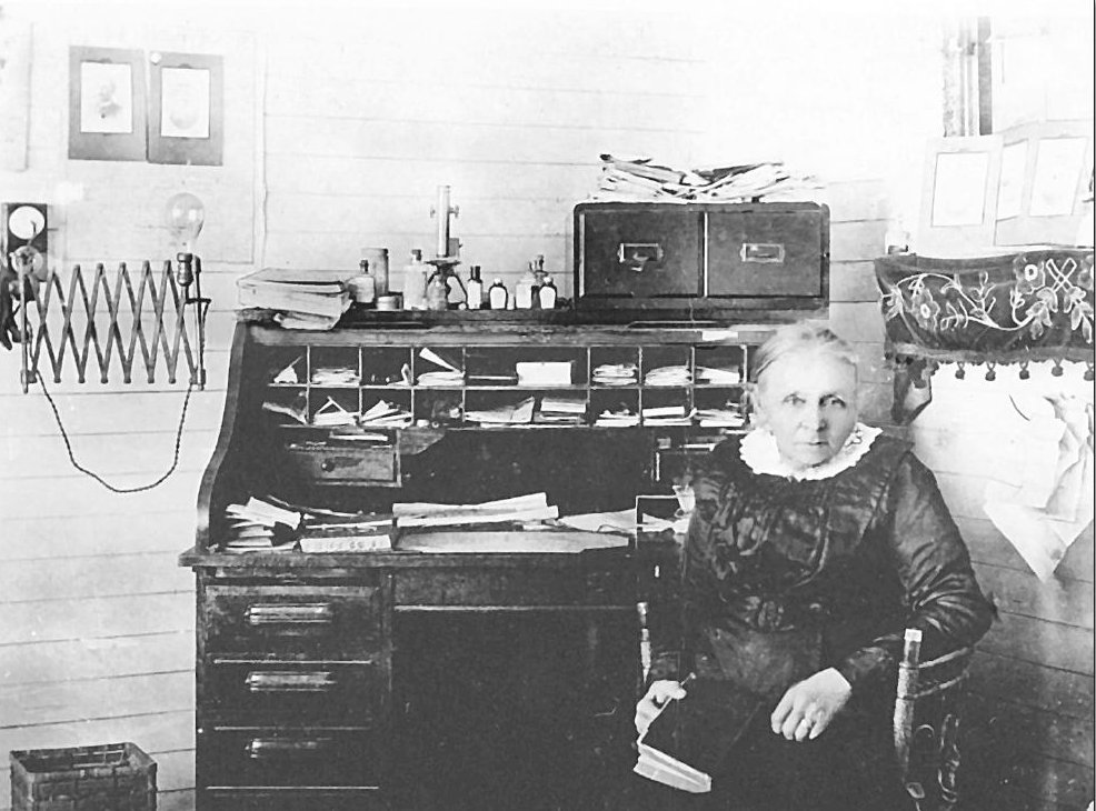 Dr Margaret Corlis seated beside a roll-top desk in her surgery